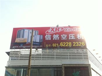 信然空壓機(jī)廣告牌很大，安裝師傅在上面象小螞蟻